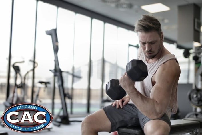 A man doing dumbbell bicep curls in a gym