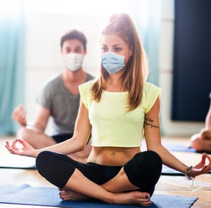 Woman doing yoga with facemask